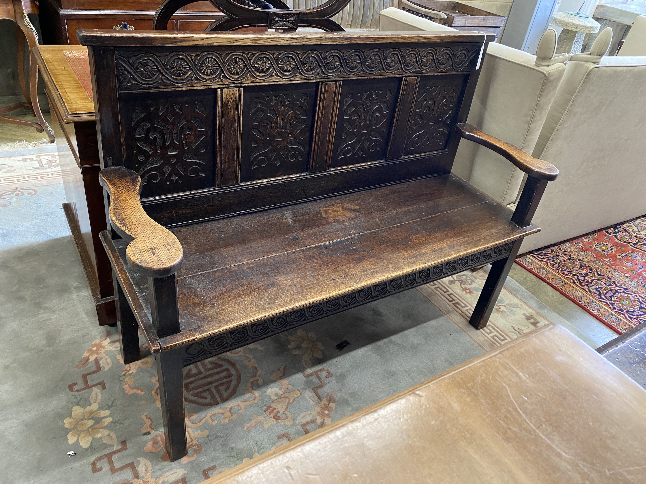 A Victorian carved panelled oak settle, constructed from old timber, width 129cm, depth 46cm, height 98cm